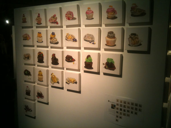 A wall with lots of paintings of cupcakes